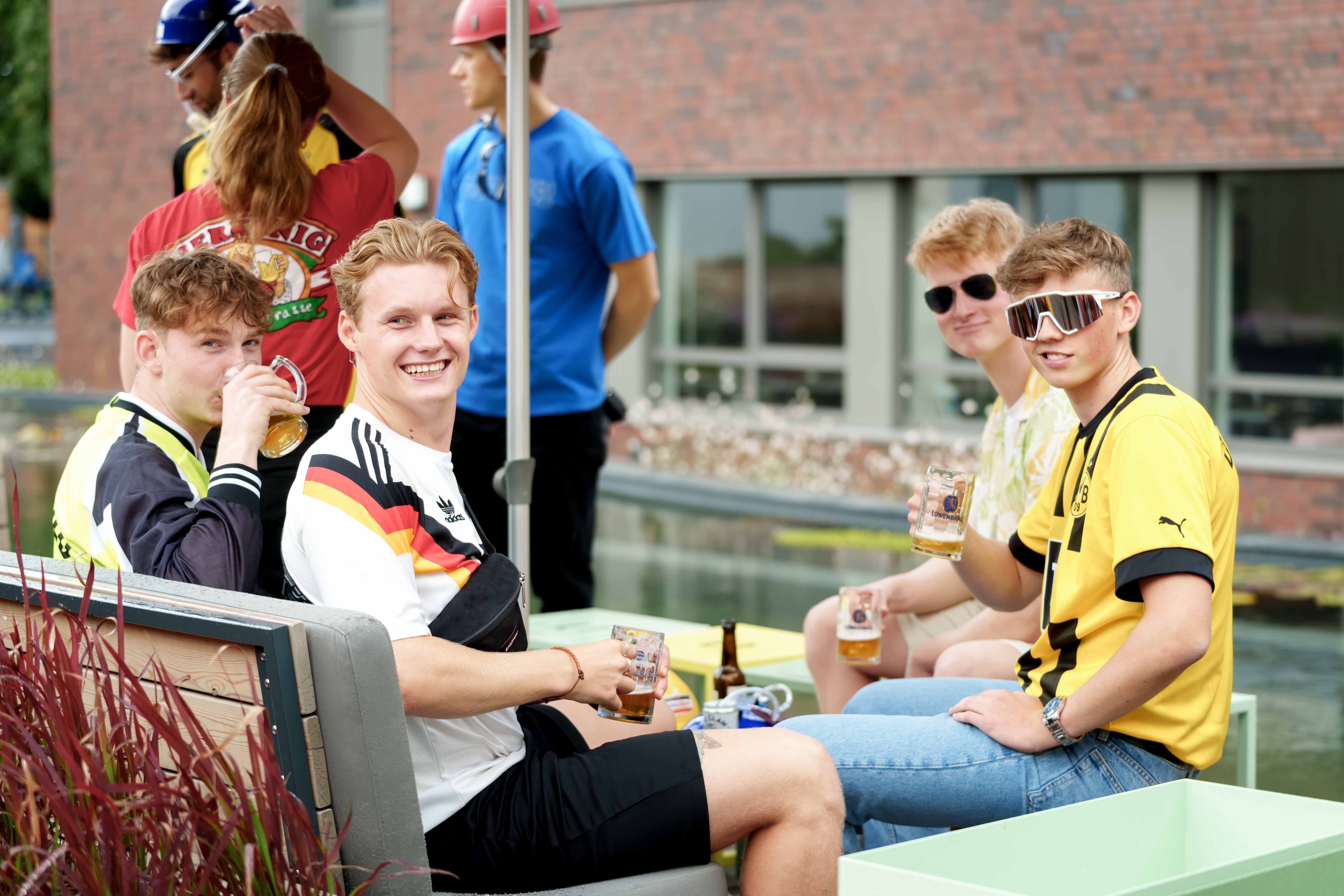 Stagiaires in feestkostuums zitten voor het WEICON-zwembad.