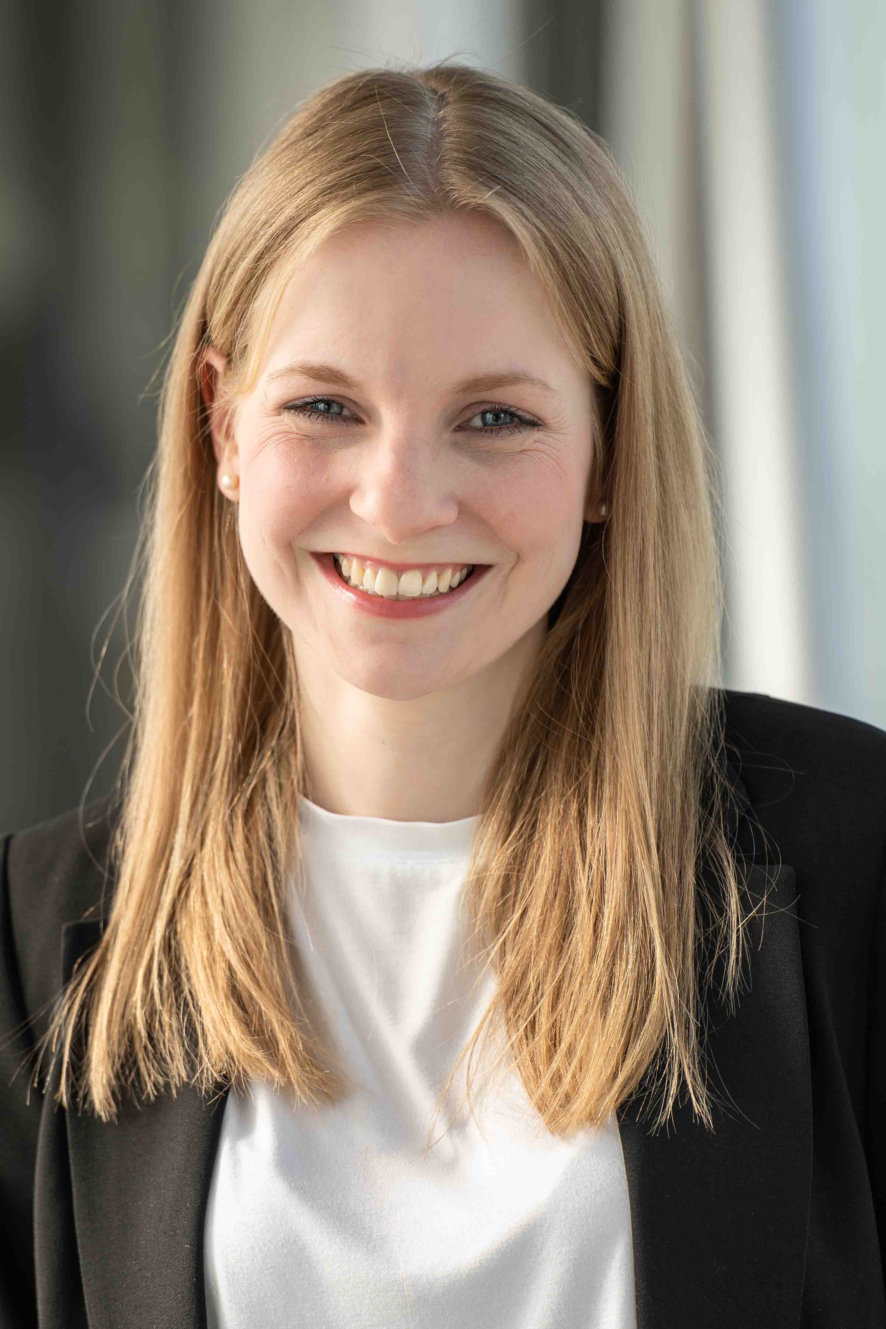woman, blonde hair, smile, business attire, black blazer